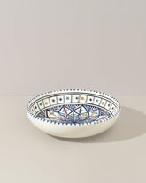A hand-painted ceramic decorative bowl with geometric patterns predominantly in blue and white colors.