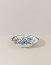 A ceramic decorative plate with a hand-painted geometric pattern predominantly in blue and white colors.