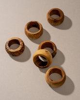 A set of olive wood napkin rings displayed on a neutral surface.