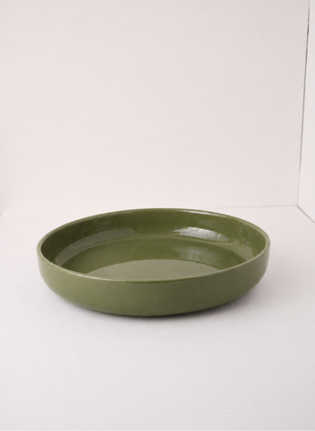 An olive green ceramic shallow bowl or tray with a glossy finish, photographed against a plain white studio background.